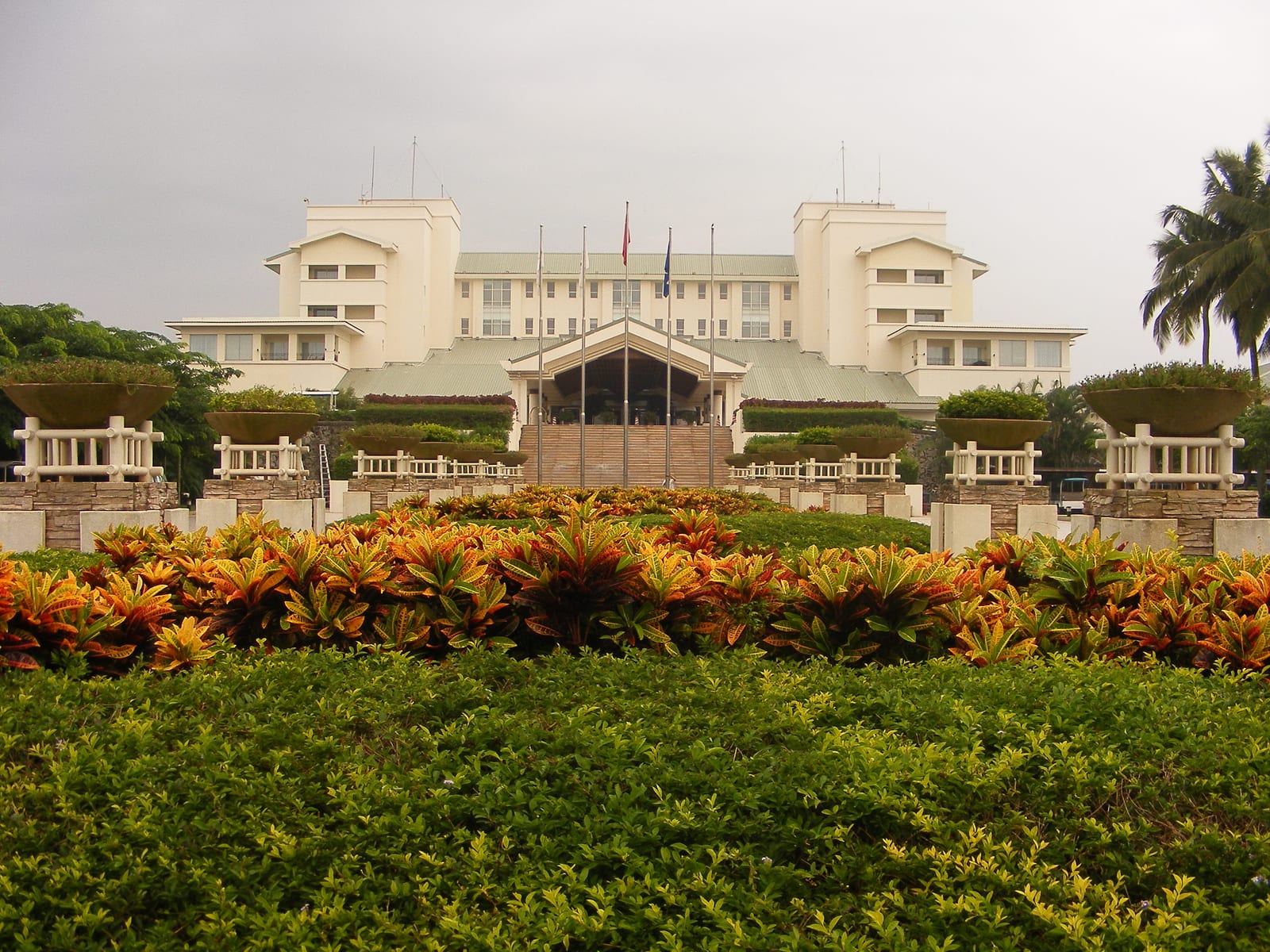 Public building, tropical planting, forecourt road and palms in Qionghai