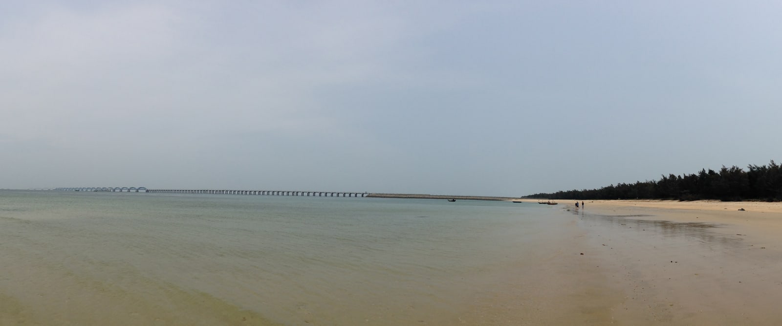 Wide beach, coastal trees and overcast shoreline on Weizhou Island in Beihai, Guangxi