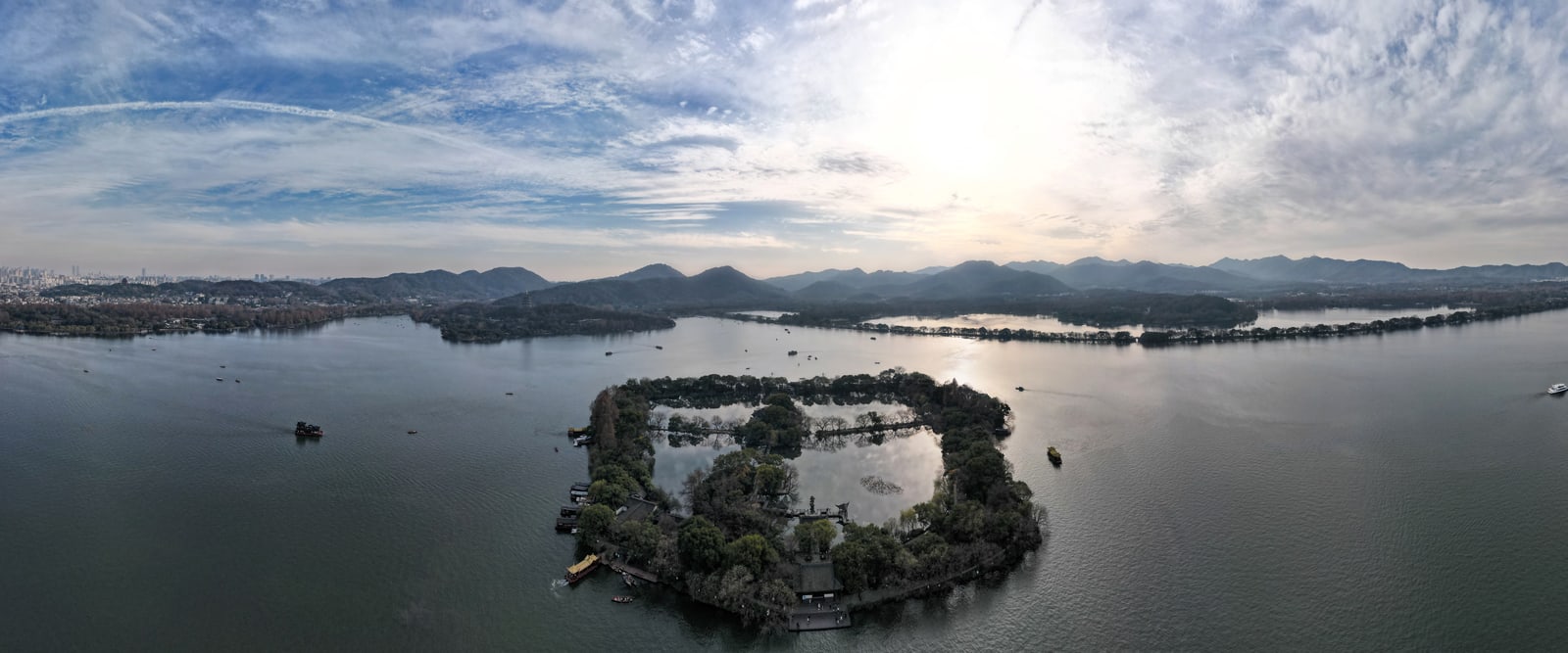 Aerial panorama of West Lake, islands, wooded shores and distant mountains in Hangzhou