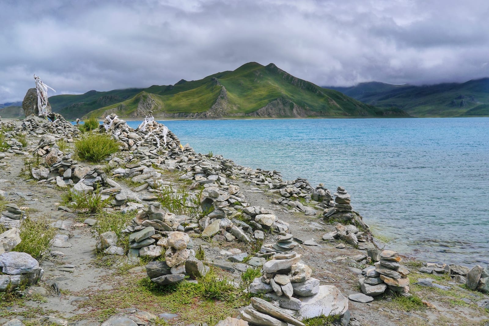 山南羊卓雍错蓝绿色湖面、玛尼石与远山