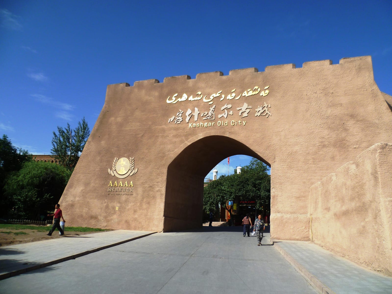 Earthen-colored gate, blue sky and visitors at Kashgar Old City